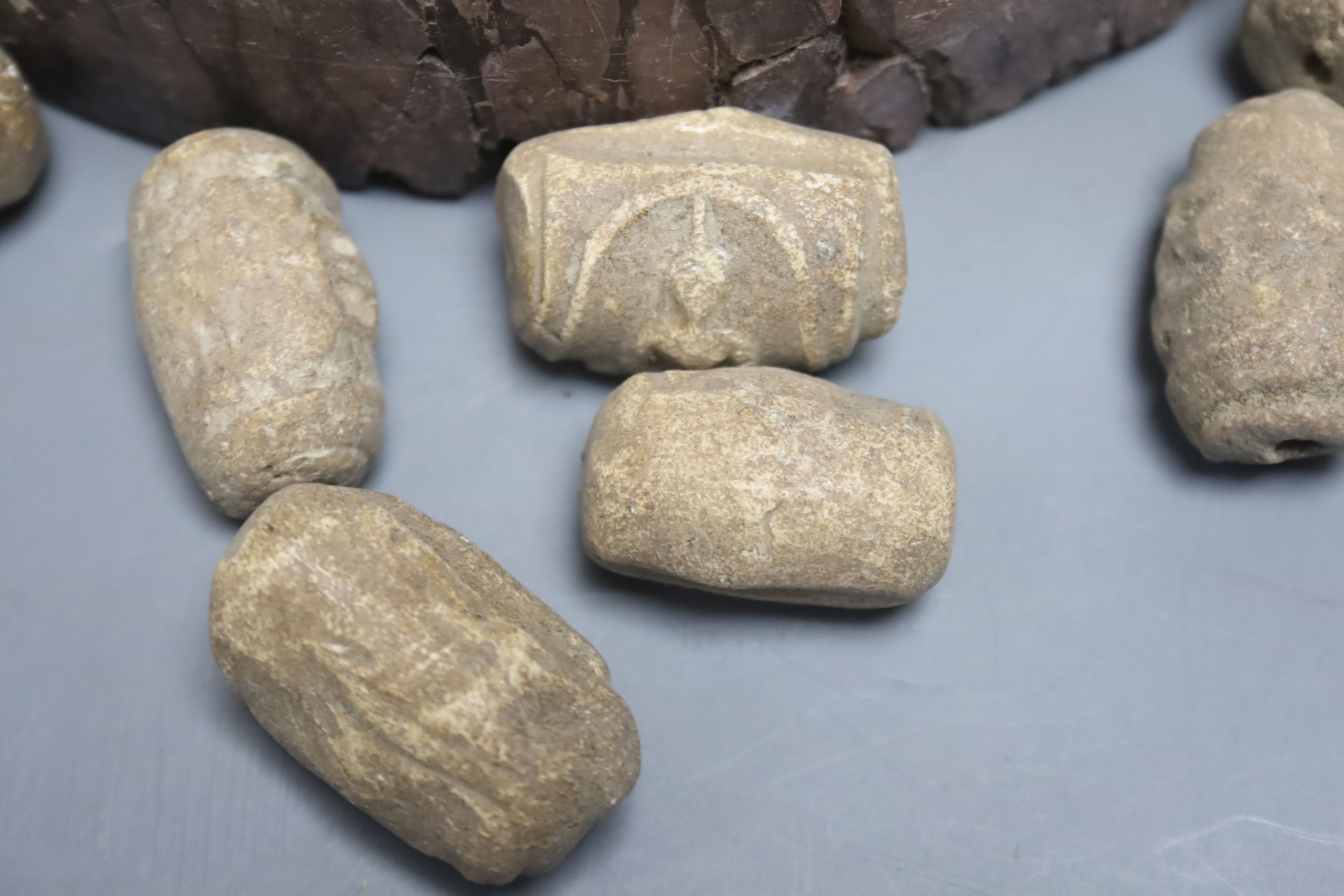 A rouge marble plinth and various Indian amulets